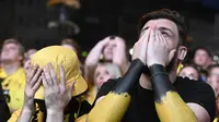 Dua fans Borussia Dortmund tampak kecewa di final Liga Champions 2023/2024 hari Minggu (02/06/2024) dini hari WIB. (Roberto Pfeil / afp)