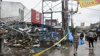Warga melintas di depan outlet Pizza Hut Delivery (PHD) Jatimelati, Bekasi, yang hancur akibat sebuah ledakan, Minggu (23/10). Akibat ledakan itu, bangunan Alfamidi yang berada di samping PHD ikut hancur dan berantakan. (Liputan6.com/Yoppy Renato)