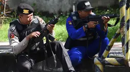 Polisi antiteror Indonesia mempersiapkan senjata selama latihan penanggulangan teror di Pelabuhan Benoa, Bali, (8/3). Simulasi penanggulangan teror ini untuk memastikan pelaksanaan prosedur standar penanganan terorisme. (AFP Photo/Sonny Tumbelaka)
