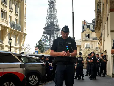 Petugas polisi berkumpul di sebuah jalan dekat Menara Eiffel jelang malam upacara pembukaan Paralimpiade Paris 2024, Selasa, 27 Agustus 2024 di Paris. (AP Photo/Thomas Padilla)