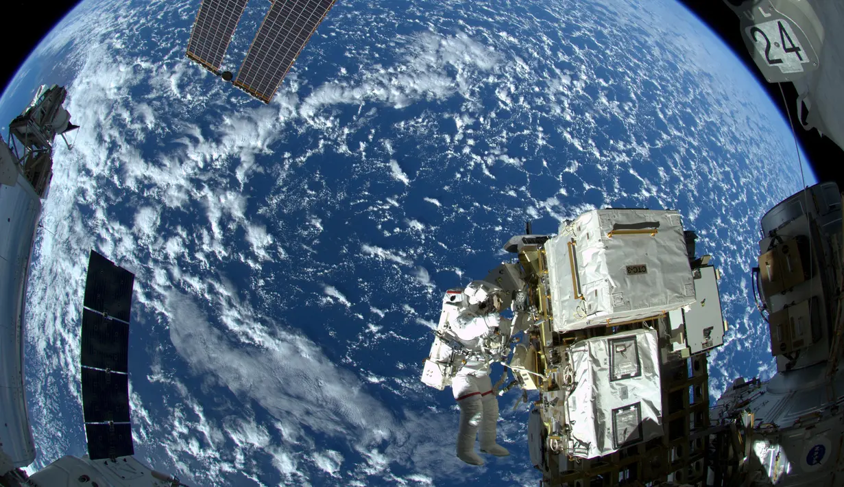 Astronot NASA Reid Wiseman saat bekerja di Stasiun luar angkasa Quest airlock dalam ekspedisi 41 awak di  Stasiun Luar Angkasa Internasional, (08/10/2014). Stasiun Luar Angkasa Internasional merayakan hari jadinya ke-15. (REUTERS/NASA)