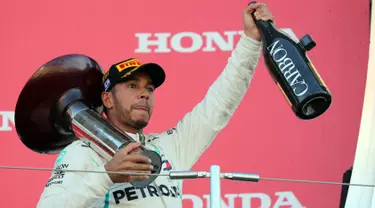 Pembalap Mercedes, Lewis Hamilton mengangkat trofi setelah memenangi Formula Satu (F1) Grand Pix Jepang di Sirkuit Suzuka, Jepang (7/10). Dengan kemenangan ini, Hamilton unggul 67 poin atas pesaing terdekatnya, Sebastian Vettel. (AP Photo/Ng Han Guan)