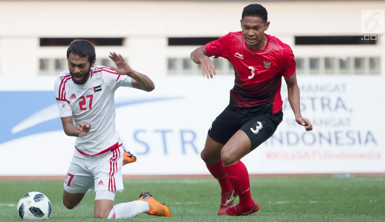 Pemain Uni Emirat Arab (UEA), Zayed Alameri (kiri) terjatuh saat berebut bola dengan bek Indonesia Andy Setyo pada laga Asian Games 2018 di Stadion Wibawa Mukti, Jawa Barat, Jumat (24/8). (Bola.com/Vitalis Yogi Trisna)