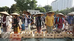 Sejumlah perempuan asal Pegunungan Kendeng, Jawa Tengah melakukan aksi semen kaki di depan Istana Negara, Jakarta, Selasa (12/4). Aksi tersebut merupakan bentuk protes atas pembangunan pabrik semen di wilayah mereka. (Liputan6.com/Immanuel Antonius) 