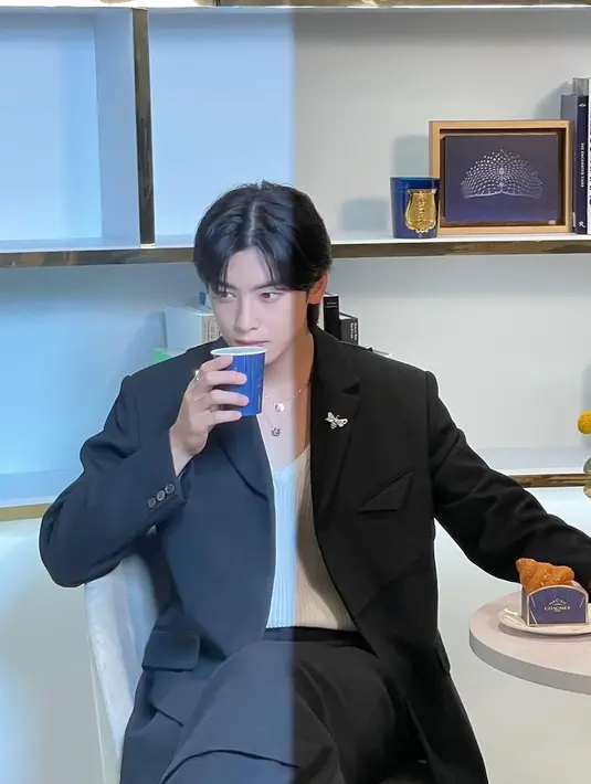 Dalam fotonya, Cha Eun Woo terlihat duduk santai sambil menikmati secangkir minuman hangat. Ada pula makanan ringan yang terletak di mejanya. (Foto: Instagram/ eunwo.o_c)
