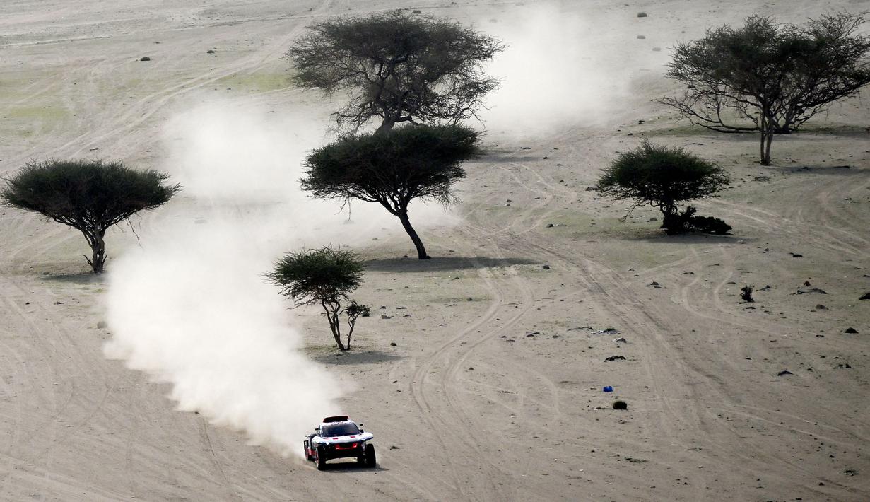 Pebalap Audi, Carlos Sainz, saat beraksi di etape 1 Reli Dakar 2023 di Sea Camp, Arab Saudi, Minggu (1/1/2023). (AFP/Franck Fife)
