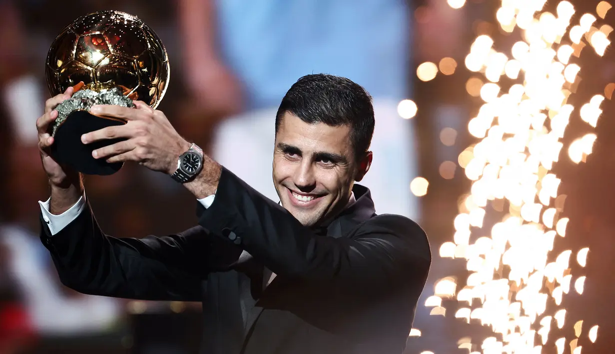 Pemain Manchester City, Rodri mengangkat trofi penghargaan Ballon d'Or 2024 pada acara yang berlangsung di Theatre du Chatelet, Paris, Selasa (29/10/2024) dini hari WIB. (AFP/Franck Fife)