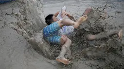 Turis bergulat di kubangan lumpur saat mengikuti Festival lumpur Boryeong di pantai Daecheon, Boryeong, Korea Selatan, (15/7). Festival ini digelar setiap tahun sekali pada bulan Juli. ( REUTERS/Kim Hong-Ji)
