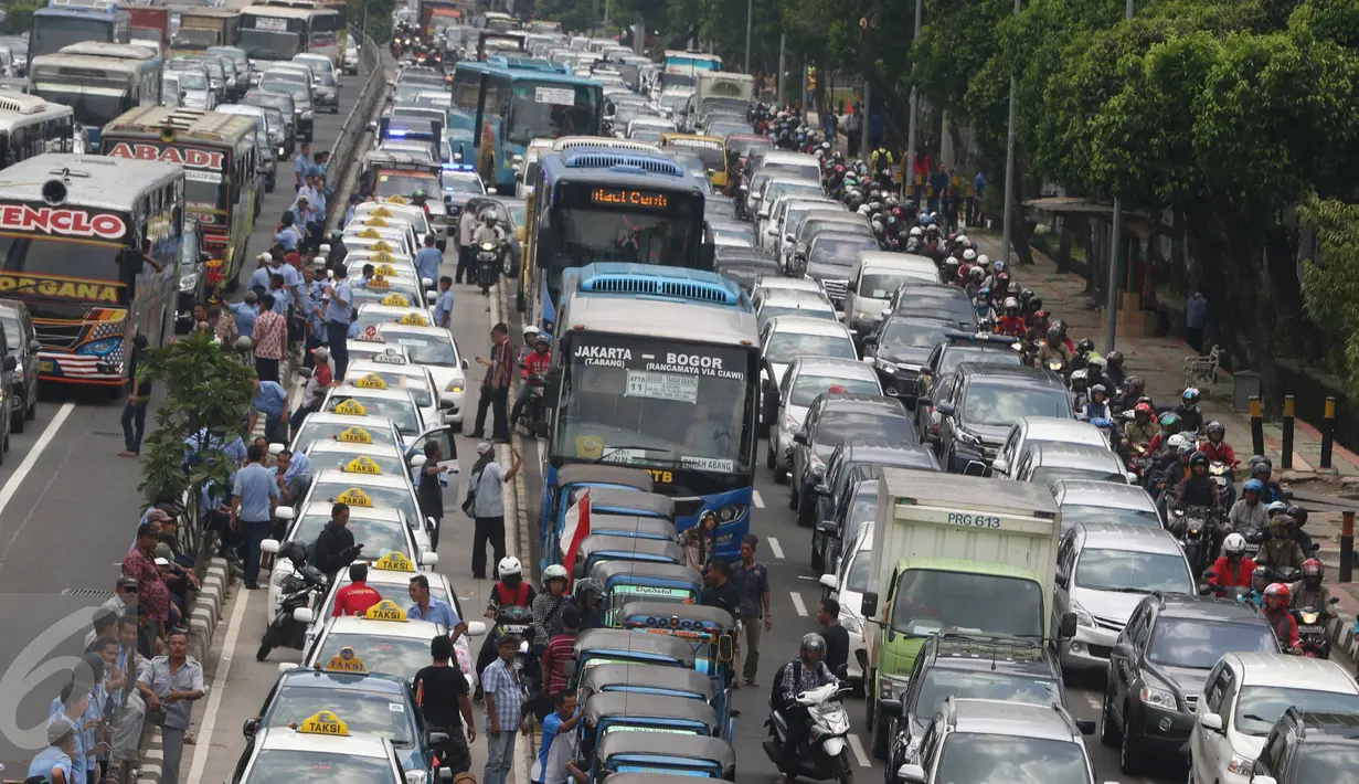Bus APTB terlihat diantara kendaraan yang terjebak macet di tol dalam kota dan Jalan Gatot Subroto, Jakarta, Selasa (22/3). Ribuan sopir taksi memblokir jalan protokol itu hingga membuat kendaraan lain tidak bisa lewat. (Liputan6.com/Immanuel Antonius)