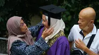 Ilustrasi wisuda, memeluk orang tua. (Photo by Solehuddin Din: https://www.pexels.com/photo/parents-greeting-daughter-university-graduate-10460163/)