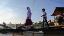 Sejumlah siswa menaiki perahu darurat untuk menyeberangi Sungai Peusangan pasca banjir bandang yang menghancurkan desa-desa di sekitarnya di kabupaten Bireuen, provinsi Aceh, Indonesia pada Senin 5 Januari 2026. Secara resmi, Dinas Pendidikan dan Kebudayaan (Disdikbud) Bireuen telah menetapkan jadwal masuk sekolah usai libur semester pada Senin (5/1/2025). (CHAIDEER MAHYUDDIN/AFP)