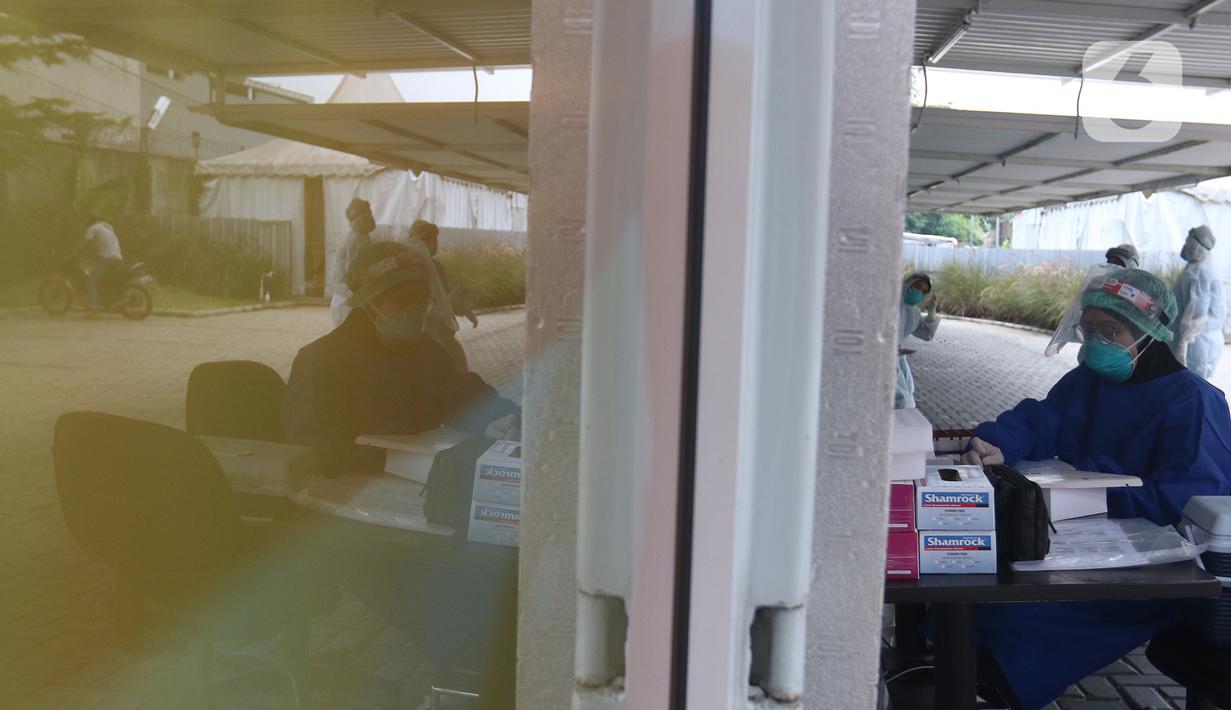 Petugas kesehatan beristirahat sambil menunggu warga yang akan melakukan tes usap (swab test) PCR di Jakarta, Senin (25/10/2021). Presiden Joko Widodo atau Jokowi mengarahkan untuk menurunkan harga tes PCR menjadi Rp300 ribu dan masa berlaku diperpanjang 3x24 jam.  (Liputan6.com/Herman Zakharia)