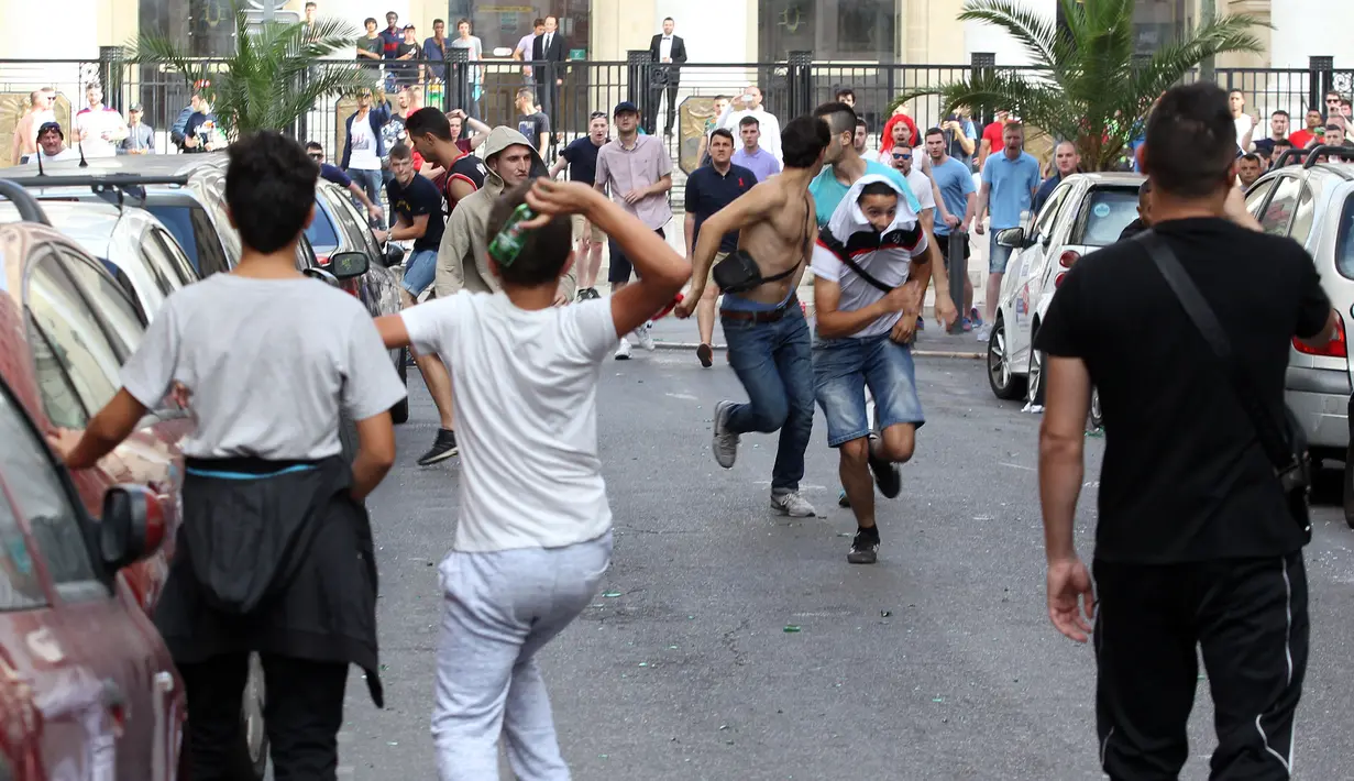 Fans Inggris dan Rusia saling melempar botol bir saat bentrok terjadi jelang pertandingan Inggris dan Rusia di kota Marseille, Prancis (11/6/2016).  (AFP Photo/Jean CM) 