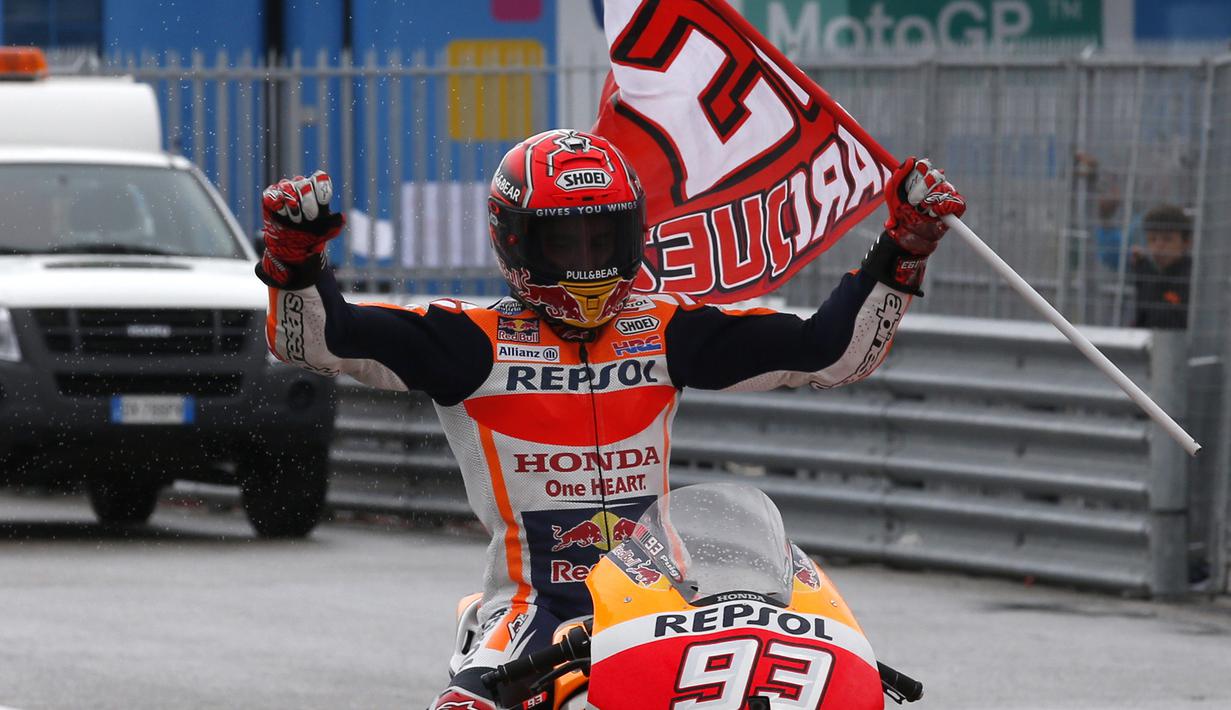 Marc Marquez nenbawa bendera usai tampil sebagai juara pada balapan MotoGP San Mariono di Sikuit Marco Simoncelli, Misano Adriatico, Italia (10/9/2017). (AP/Antonio Calanni)