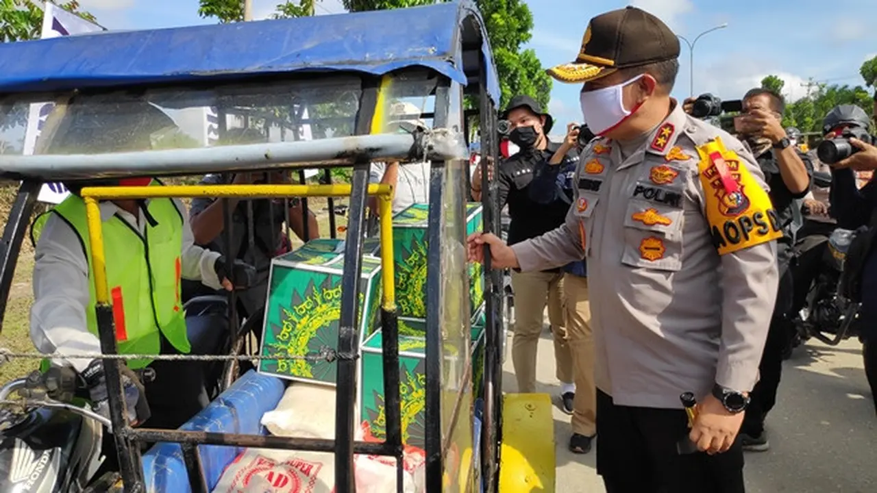 Kapolda Riau Irjen Agung Setya Imam Effendi berbincang dengan pengemudi becak motor yang mengantarkan sembako kepada masyarakat terdampak Covid-19 di Pelalawan