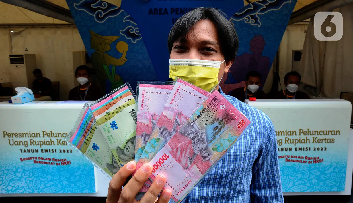 Warga menunjukkan uang rupiah kertas tahun emisi 2022 usai melakukan penukaran di Hall Basket Gelora Bung Karno (GBK), Jakarta, Minggu (21/8/2022). Uang baru TE 2022 memiliki kualitas lebih baik yang menjamin masa edar lebih lama serta teknologi unsur pengamanan semakin sulit untuk dipalsukan. (merdeka.com/Arie Basuki)