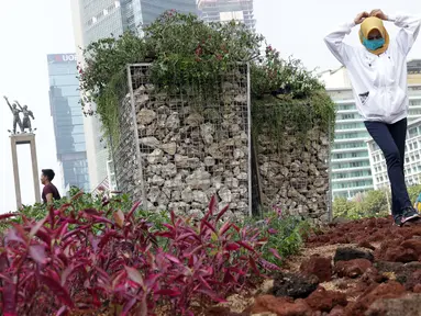 Warga berjalan-jalan di area taman dekat Instalasi Gabion saat CFD di kawasan Bundaran Hotel Indonesia, Jakarta, Minggu (25/8/2019). Instalasi Gabion berdiri di lokasi bekas seni anyaman bambu Getah Getih dan diletakkan bebatuan sebagai penghias. (Liputan6.com/Helmi Fithriansyah)