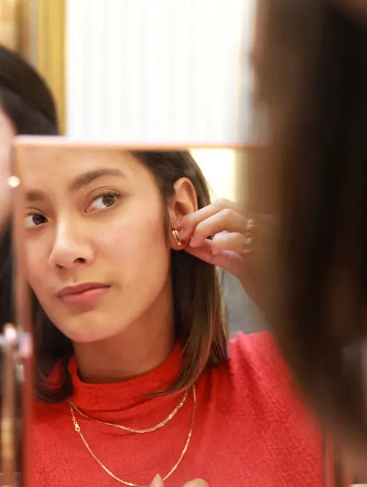 Tara Basro saat memasang anting berwarna emas di telinga kirinya. Terlihat wajah Tara yang begitu serius memperhatikan pemakaian anting-antinya. Tara memang aktris yang sangat cantik dan memesona parasnya. Wajar saja banyak yang jatuh hati padanya (KapanLagi.com/Adrian Utama Putra)