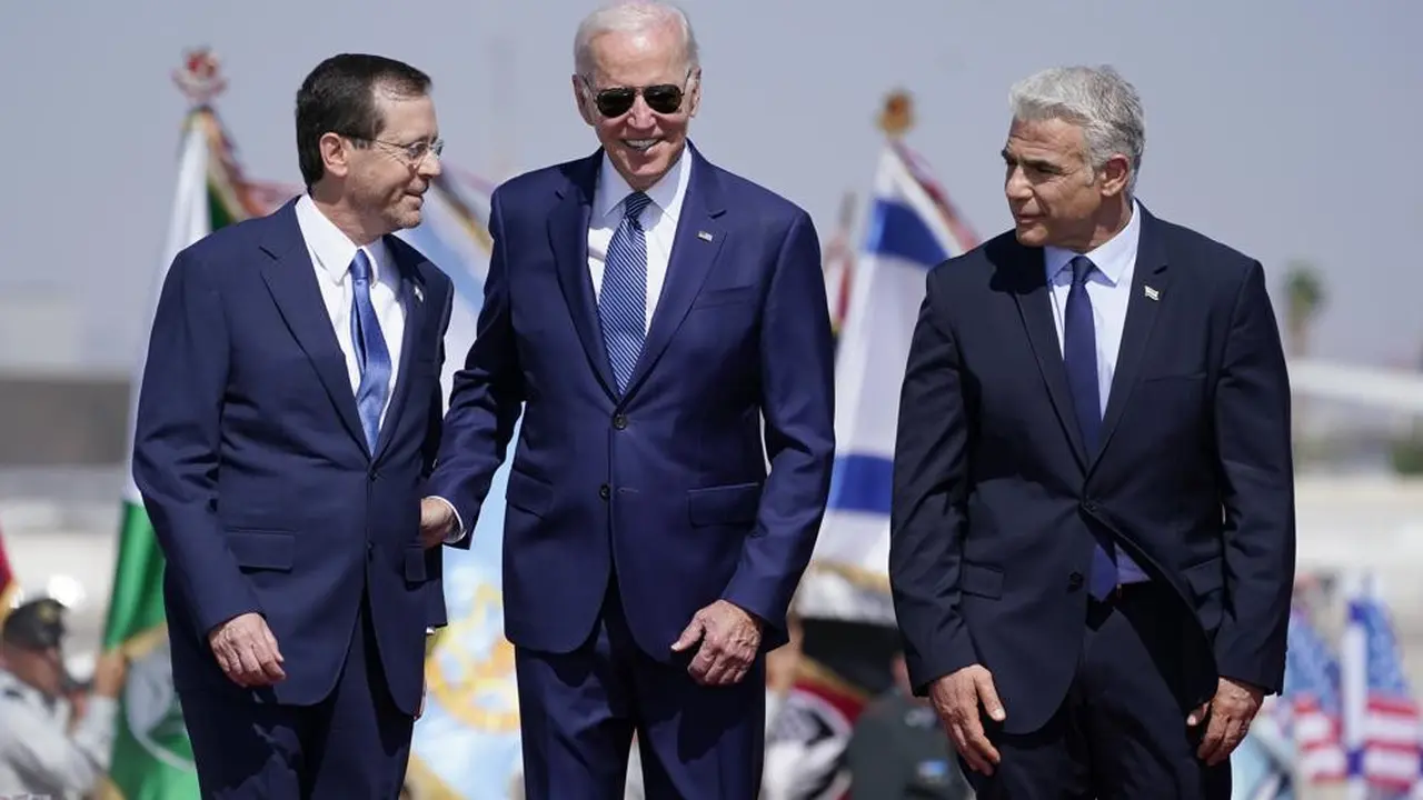 Presiden Joe Biden berdiri bersama Perdana Menteri Israel Yair Lapid (kanan) dan Presiden Isaac Herzog (kiri) setelah tiba di Bandara Ben Gurion, Rabu, 13 Juli 2022, di Tel Aviv. (Foto AP/Evan Vucci)