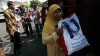 Warga membawa semboko dari Presiden Jokowi saat open house di Istana Kepresidenan Gedung Agung, Yogyakarta, Sabtu (9/7). Open House ini diikuti oleh ribuan masyarakat yang berada di Yogyakarta. (Liputan6.com/Boy Harjanto)