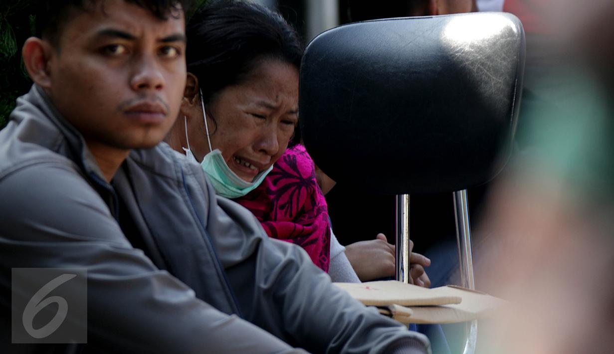 Keluarga korban jatuhnya pesawat Hercules C-130 menangis saat menunggu di halaman RSUP Haji Adam Malik, Medan, Sumatera utara, Kamis (2/7/2015). Mereka cemas menanti kepastian kabar anggota keluarganya dari tim DVI. (Liputan6.com/Johan Tallo)