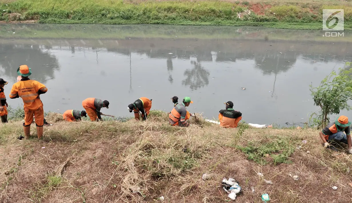 Petugas PPSU dan Sudin Tata Air Jakarta Timur membersihkan sampah dan tanaman liar di sepanjang aliran Kanal Banjir Timur (KBT), Senin (15/10). Banyak sampah yang bermunculan ke permukaan akibat debit air surut. (Merdeka.com/ Iqbal S. Nugroho)