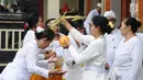 Umat Hindu memberikan air suci selama prosesi upacara mecaru di Pura Tribhuana Agung Sukmajaya Depok, Jawa Barat, Rabu (6/3). Upacara Mecaru dilaksanakan sebelum Hari Raya Nyepi pada waktu Sasih Kesanga. (Liputan6.com/Herman Zakharia)