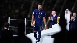 Pemain Prancis Kylian Mbappe berjalan dengan membawa penghargaan Sepatu Emas usai melawan Argentina pada pertandingan sepak bola final Piala Dunia 2022 di Stadion Lusail, Lusail, Qatar, 18 Desember 2022. Kylian Mbappe berhak membawa pulang trofi penghargaan Sepatu Emas setelah menjadi pencetak gol terbanyak selama gelaran Piala Dunia 2022. (AP Photo/Natacha Pisarenko)