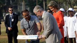 Pemain kriket India Virendar Shehwag mengajarkan Raja Philippe dan Ratu Belgia Mathilde bermain kriket di Oval Maidan di Mumbai, India, Jumat, (10/11). (AP Photo / Rajanish Kakade)