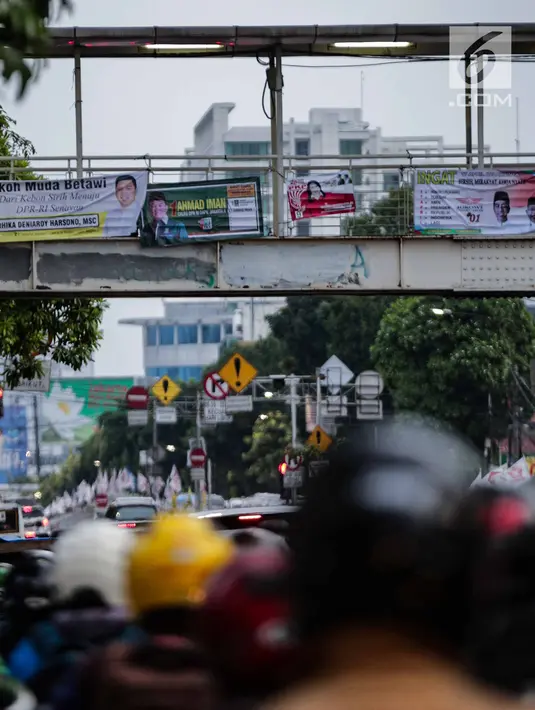 Alat peraga kampanye (APK) terpasang di jembatan penyeberangan orang (JPO) kawasan Mampang, Jakarta, Rabu (27/2). APK masih menghiasi JPO di Ibu Kota meski KPU telah melarang pemasangan di sarana dan prasarana publik. (Liputan6.com/Faizal Fanani)
