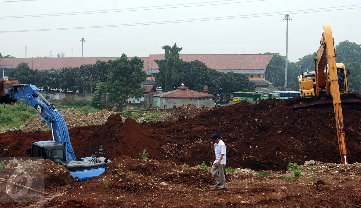 Warga melintas disekitar areal pengerukan Waduk Rambutan 1, Ciracas, Jakarta, Kamis (27/10). Beberapa waktu lalu, aktivitas pengerukan Waduk Rambutan I sempat terhenti akibat keterlambatan pasokan bahan bakar. (Liputan6.com/Helmi Fithriansyah)