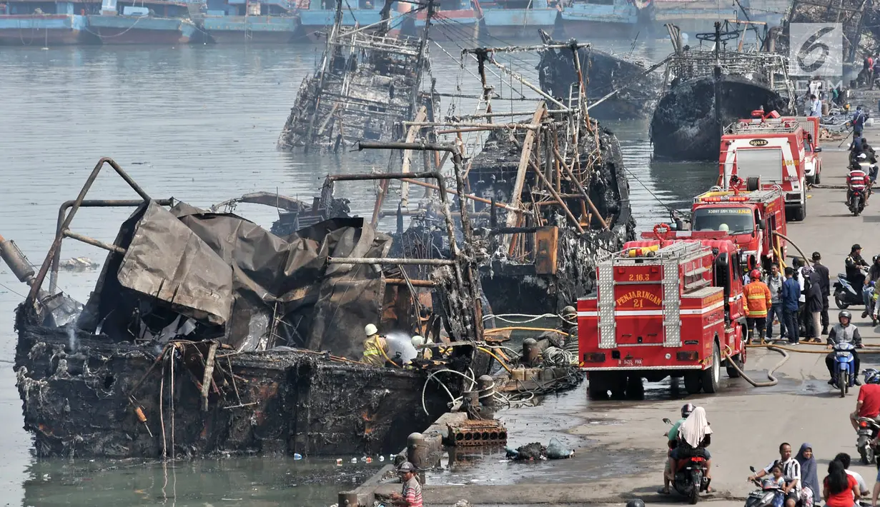 Petugas pemadam kebakaran melakukan pendinginan kapal yang ludes dilalap api di Pelabuhan Muara Baru, Jakarta, Minggu (24/2). Dalam peristiwa tersebut sebanyak tiga orang mengalami sesak napas. (Merdeka.com/Iqbal Nugroho)