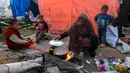 Seorang wanita memasak di sebuah kamp untuk pengungsi Palestina di Khan Yunis, di Jalur Gaza selatan pada 29 Desember 2024. (BASHAR TALEB/AFP)