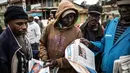 Warga membaca koran di daerah kumuh Kawangare di Nairobi (10/8). Warga Kenya tengah menunggu hasil pemilihan presidennya, antara Uhuru Kenyatta dan pesaingnya, Raila Odinga. (AFP Photo/Marco Longari) 