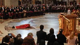 Paus Fransiskus berdoa sambil berbaring di lantai dalam prosesi Jumat Agung memperingati penyiksaan Yesus sebelum disalibkan di Basilika Santo Petrus, Vatikan, Jumat (19/4). (AP Photo/Alessandra Tarantino)