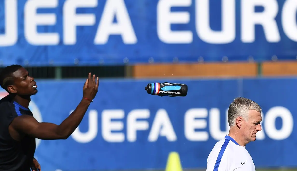 Paul Pogba melempar botol minum saat pelatih, Didier Deschamps sedang mengawasi latihan sebelum melawan Jerman pada laga semi-final di Centre d'Entrainement Robert Louis-Dreyfus, Marseille, (6/7/2016).(AFP/Franck Fife)