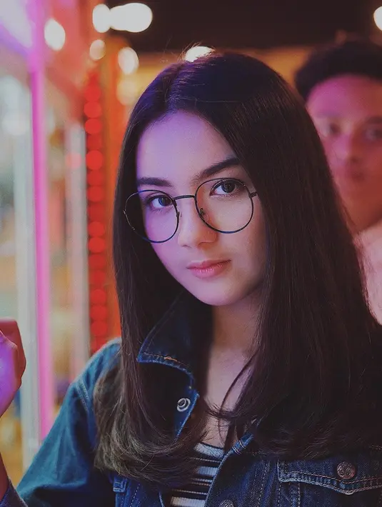 Memadukan jaket denim dengan inner stripe adalah paduan sempurna untuk penampilan casual. Fashion item kacamata dengan frame besar membuat penampilan gadis 2000 ini terlihat edgy dan chic. (Liputan6.com/IG/@ersyaurel)