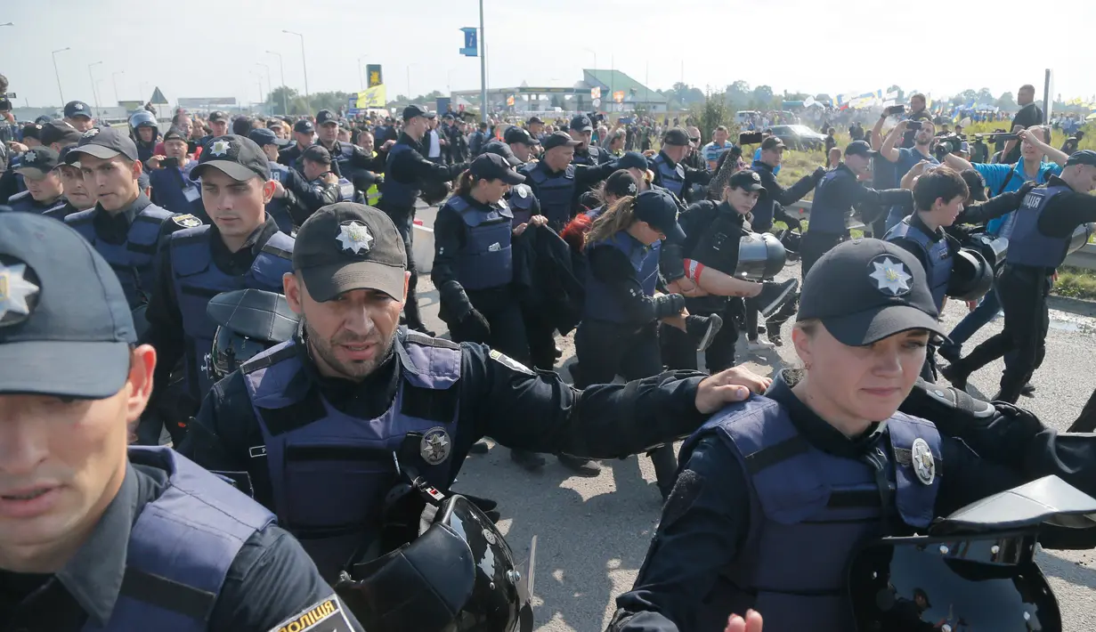 Polisi Ukraina menahan aktivis Femen di titik cek Krakovets di perbatasan Ukraina-Polandia, di Ukraina, (10/9).  Mikheil Shaakashvili berusaha kembali ke Ukraina walaupun Paspor Ukraina dan Georgia miliknya sudah tidak berlaku. (AP Photo / Efrem Lukatsky)