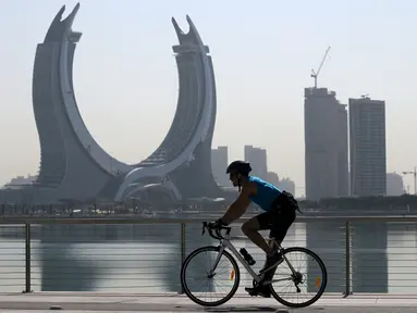 Seorang pria mengendarai sepedanya menjelang turnamen sepak bola Piala Dunia Qatar 2022 di Doha, Rabu (16/11/2022). Piala Dunia 2022 Qatar yang dinobatkan Piala Dunia dalam sejarah sepak bola akan segera mulai pada Minggu (20/11). (AFP/Raul Arboleda)