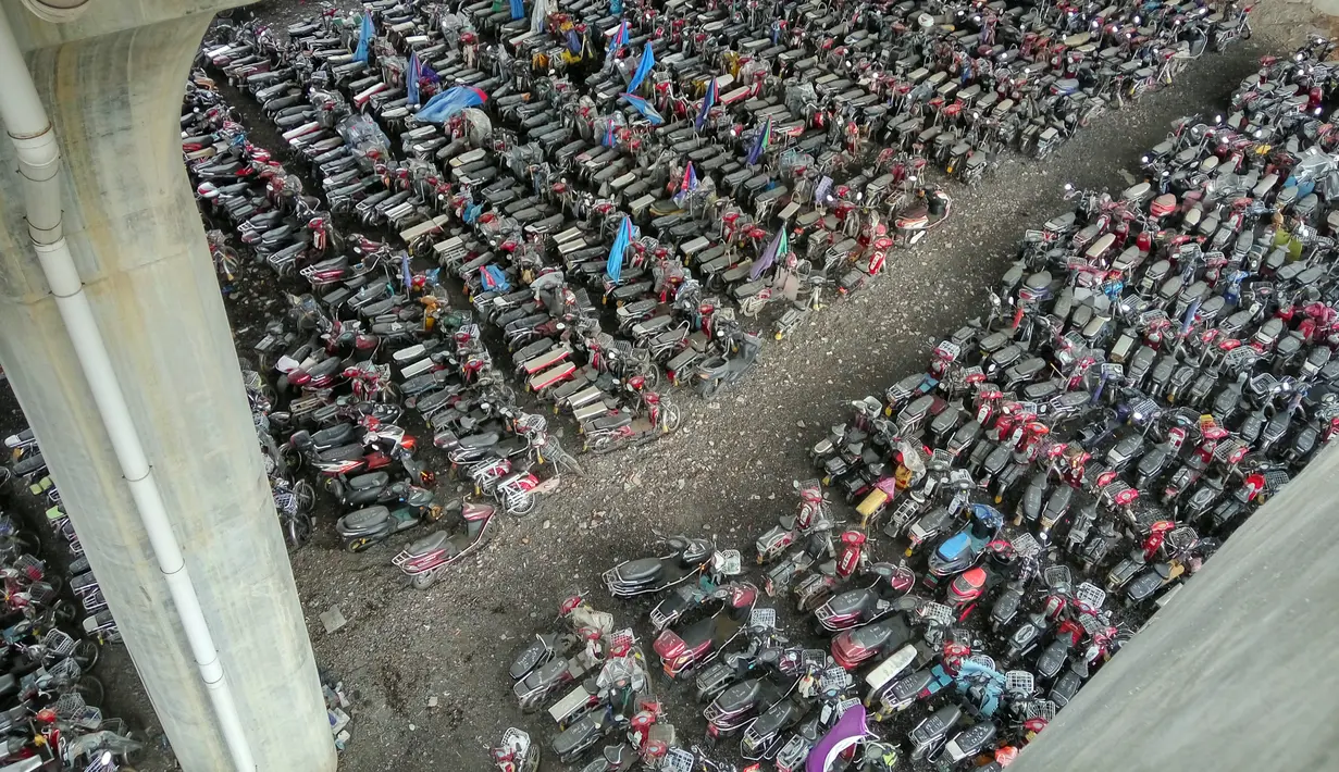 Barisan sepeda listrik dan motor bekas di bawah jembatan tol Nantou Jembatan di Shenzhen, Provinsi Guangdong, China (5/4). Sebagai besar sepeda motor yang di sita ini tidak memenuhi standarisasi kelayakan jalan. .(AFP Photo/China Out)