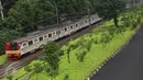 KRL melintas di samping taman yang berada di kawasan Rawajati, Jakarta, Rabu (17/5). Lahan seluas 2.200 meter persegi di bantaran rel KA yang dulu kumuh kini telah menjadi ruang terbuka hijau baru di Ibu Kota. (Liputan6.com/Immanuel Antonius)