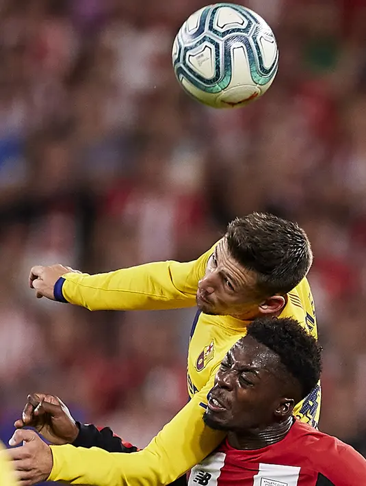 Pemain Barcelona, Clement Lenglet berebut bola dengan Striker Athletic Bilbao, Inaki Williams  selama pertandingan perdana La Liga Spanyol di Stadion San Mames, Sabtu (17/8/2019). Bilbao menang tipis atas Barcelona dengan skor 1-0. (AP Photo/Ion Alcoba Beitia)