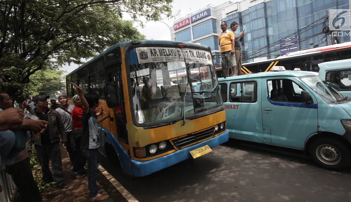 Metro Mini trayek Kampung Melayu-Tanah Abang ikut brunjuk rasa dengan Sopir angkot trayek 44 di sekitar Stasiun Tebet, Jakarta, Senin (12/2). Sopir angkot menutup akses jalan jembatan layang Tebet menuju Kampung Melayu. (Liputan6.com/Arya Manggala)