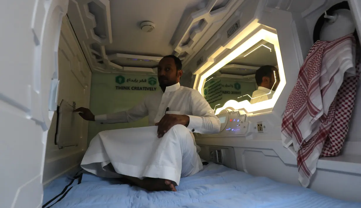 Seorang pria Arab Saudi menggunakan fasilitas kamar kapsul di Makkah, 16 Agustus 2018. Konsep kamar kapsul ini dirasa bakal mempermudah pendatang yang melaksanakan ibadah haji dengan biaya yang terbatas. (AFP/AHMAD AL-RUBAYE)