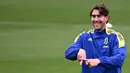 Penyerang Juventus, Dusan Vlahovic tersenyum saat ambil bagian dalam sesi latihan di tempat latihan Continassa di Turin, Italia (15/3/2022). Pada leg pertama Juventus bermain imbang dengan Villarreal 2-2. (AFP/Marco Bertorello)