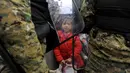 Seorang gadis migran memegang mainan di perbatasan Yunani-Macedonia (20/11/2015). Polisi melakukan penjagaan  dan mencegah para imigran untuk masuk ke negaranya. (REUTERS / Alexandros Avramidis)
