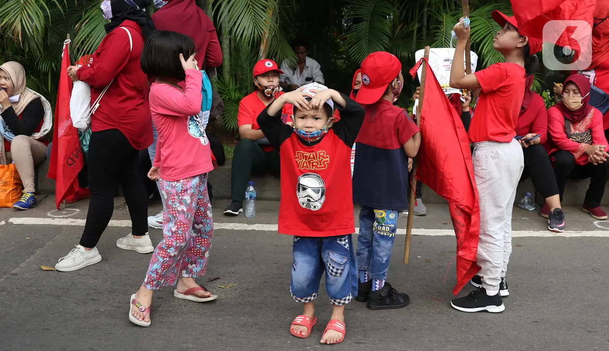 Sejumlah anak terlihat dalam aksi unjuk rasa menolak pengesahan UU Omnibus Law Cipta Kerja di Kawasan Patung Kuda, Jakarta, Jumat (16/10/2020). Meski sudah ada imbauan untuk tidak membawa anak-anak dalam aksi unjuk rasa namun sejumlah orang tua tetap menyertakan. (Liputan6.com/Helmi Fithriansyah)