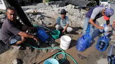 Warga antre memanfaatkan air bersih dari kebocoran pipa PDAM di Jalan Lagarutu, Palu Sulawesi Tengah, Rabu (3/10). Pasca gempa tsunami warga sekitar belum mendapatkan pasokan makanan dan air bersih. (Liputan6.com/Fery Pradolo)