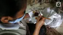 Perajin mencetak batik di rumah produksi batik tanah liek Ayesha Collection di Padang, Sumatera Barat, Kamis (25/11/2021). UMKM Ayesha yang dirintis sejak 2010 memproduksi 50 - 800 potong per bulan dengan dua jenis batik yaitu batik cetak dan batik tulis. (Liputan6.com/Fery Pradolo)