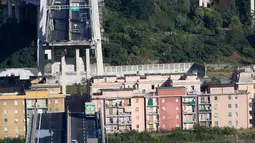 Sejumlah kendaraan berada di atas jembatan Morandi, dekat dengan bagian jalan layang yang runtuh, di kota Genoa, italia, Selasa (14/8). Jembatan yang dibangun pada 1960-an itu ambruk saat hujan deras dan angin kencang. (AP/Antonio Calanni)